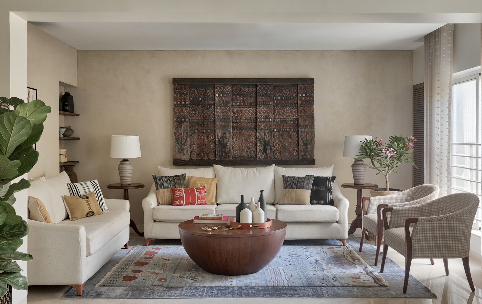 Art-filled living room with lime-washed walls and antique columns, An Oasis of Art, Pune